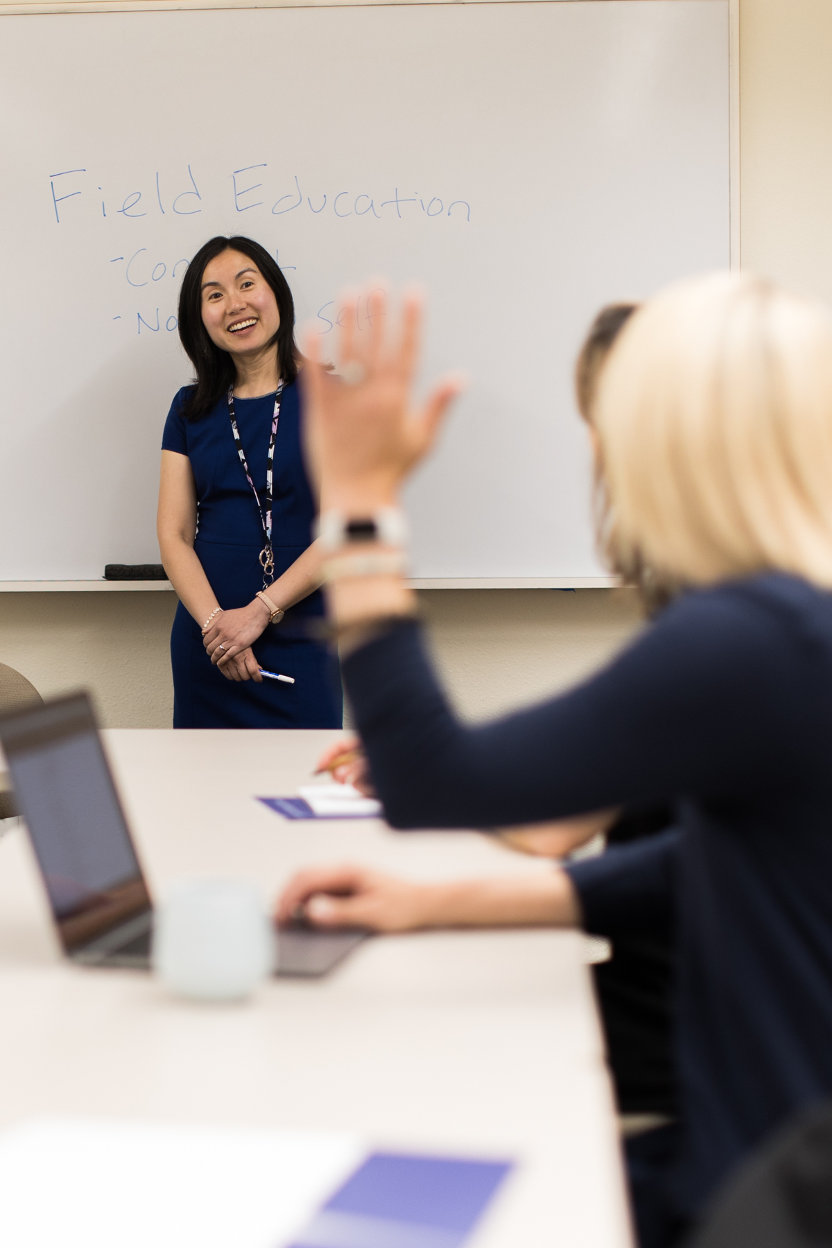 Woman asking question, teacher standing smiling